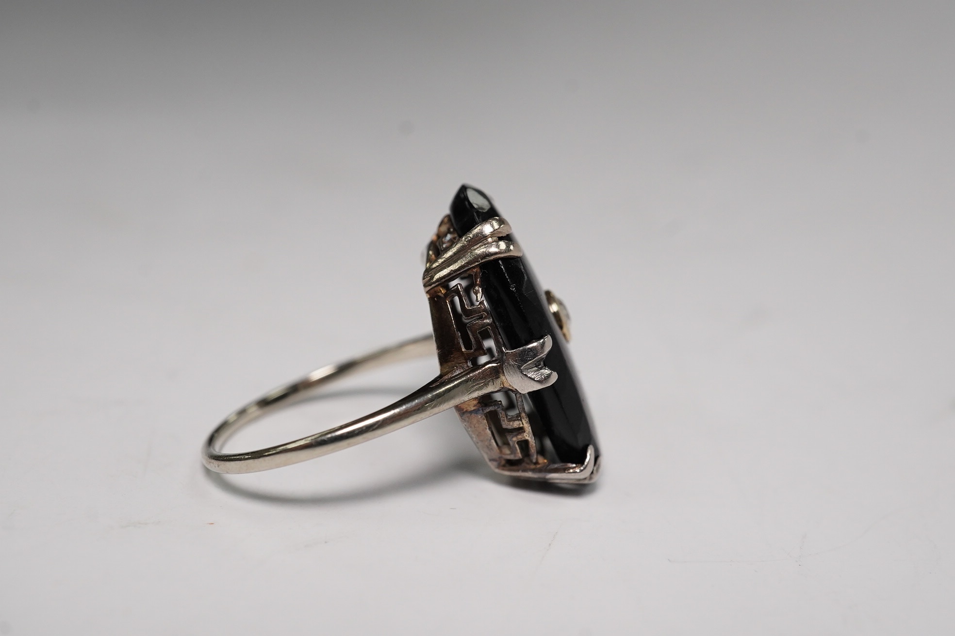 A white metal, black onyx and single stone diamond set oval ring, size M/N, gross weight 3.9 grams. Condition - poor to fair